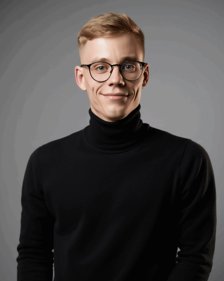 Prompt: Ein junger Mann mit blonden Haaren, schwarzem Rollkragenpullover und runder Brille steht vor neutralem grauen Hintergrund. Er lächelt dezent und blickt direkt in die Kamera. Das Licht ist weich und gleichmäßig.